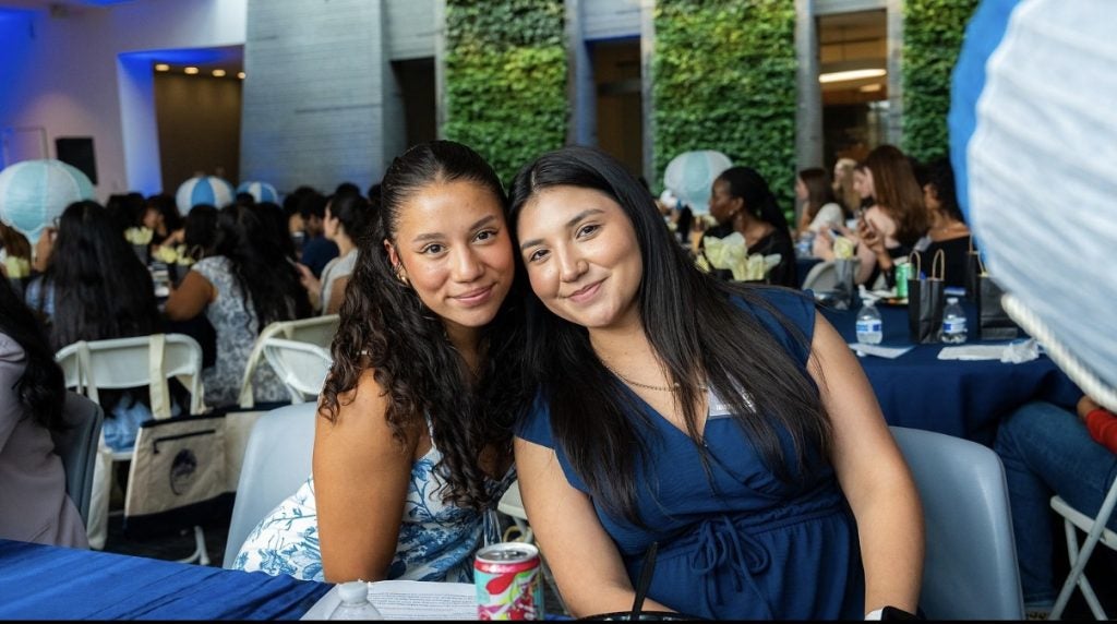 Two female students pose together at a dinner