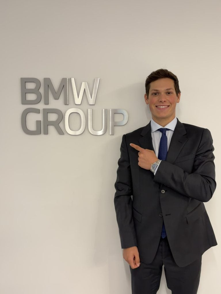 Young men in suit and tie text to BMW logo