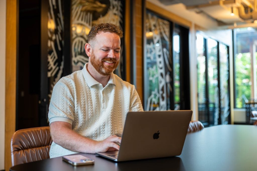 Man working on laptop and smiling