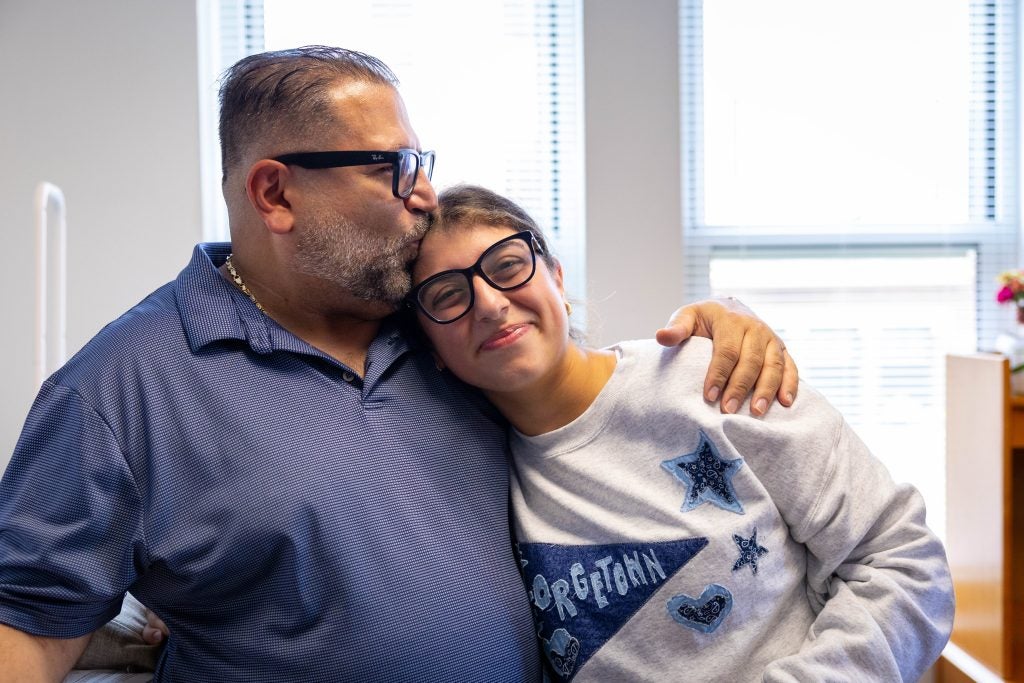Young woman with her dad embracing her as she smiles