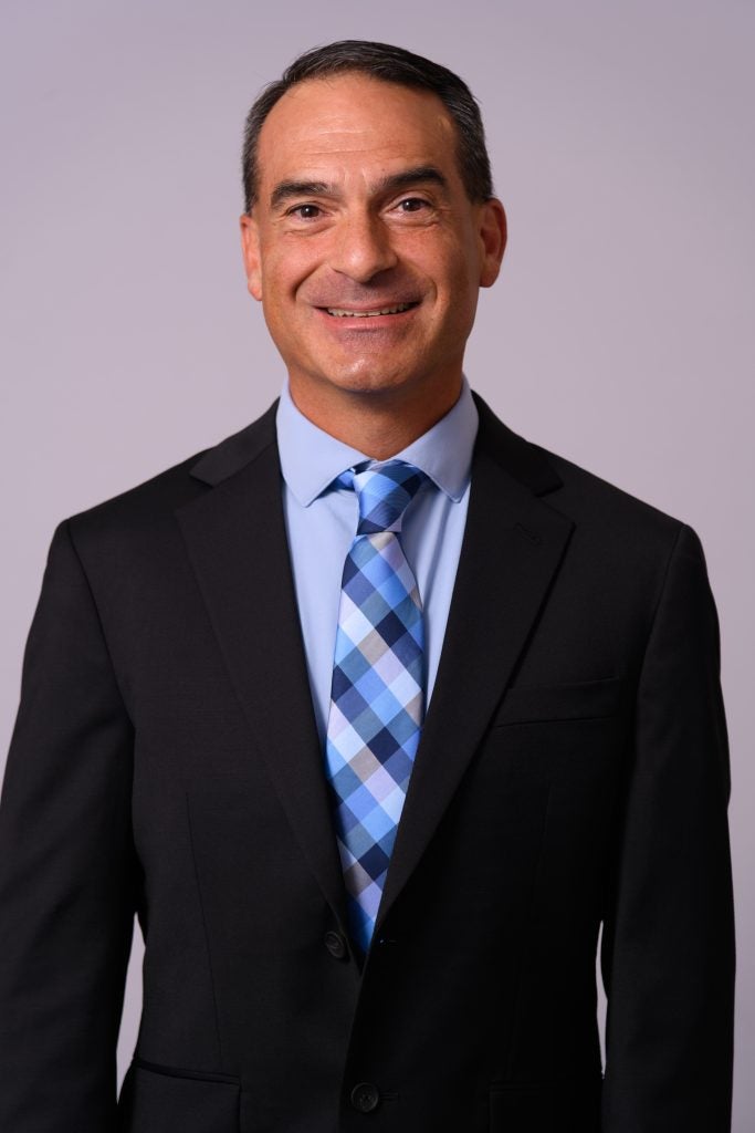 Man smiling while wearing suit and tie