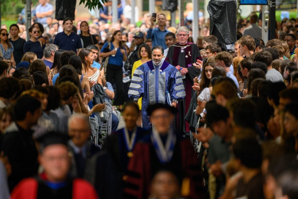 Eduardo Peñalver processes onto stage in academic regalia as the crowd looks on