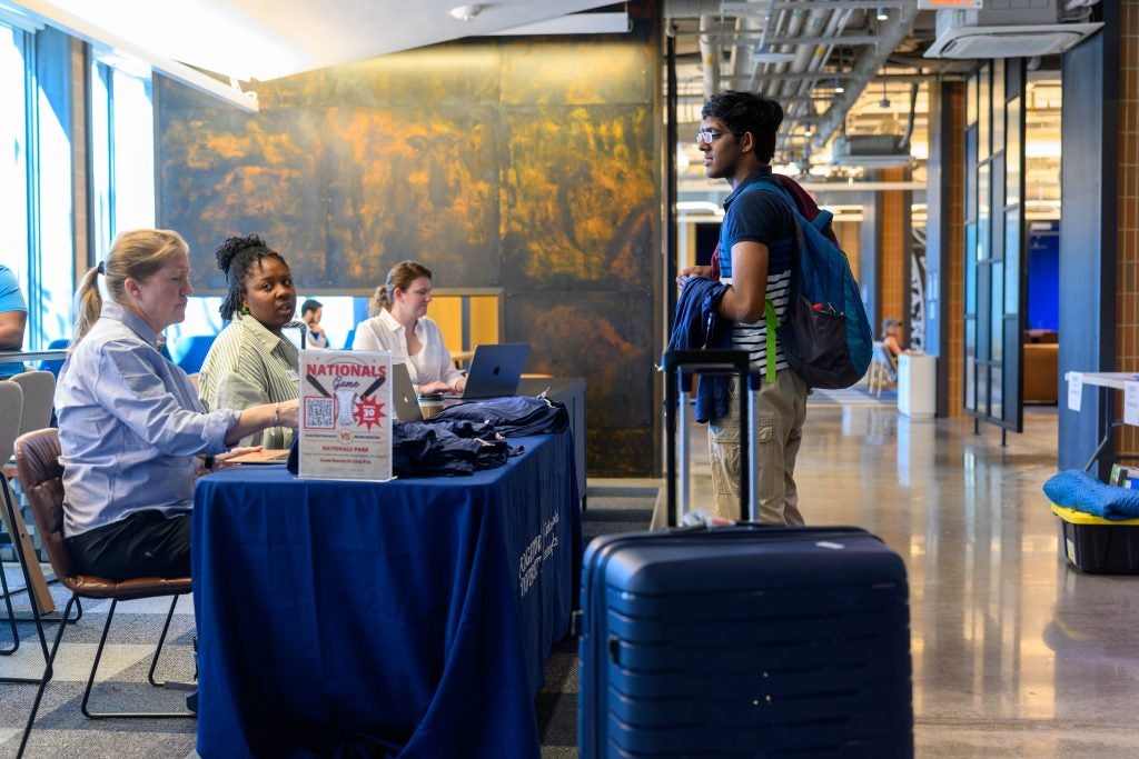 A young man at a help desk during move in