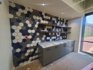 The tiled backsplash of a wall in a room under construction