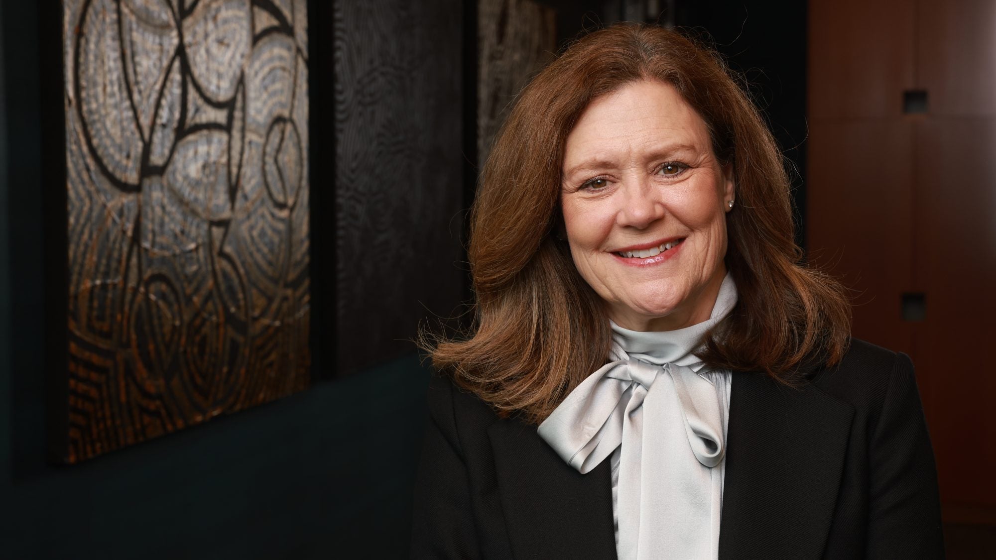 Older Caucasian woman in professional attire and smiling