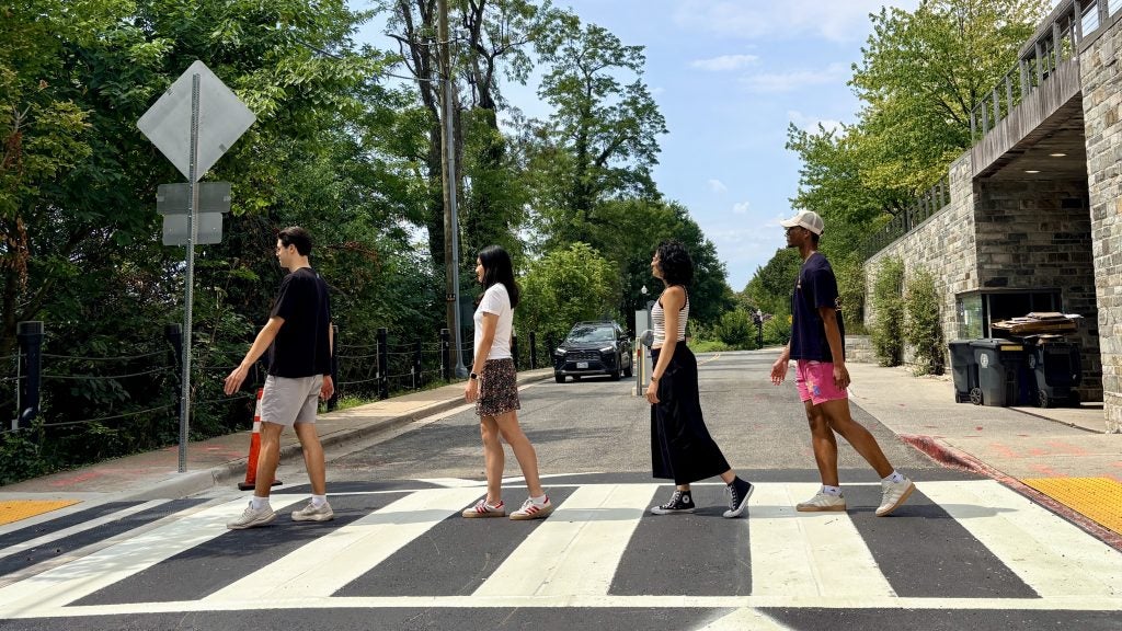 Students walk across a crosswalk on Georgetown's campus