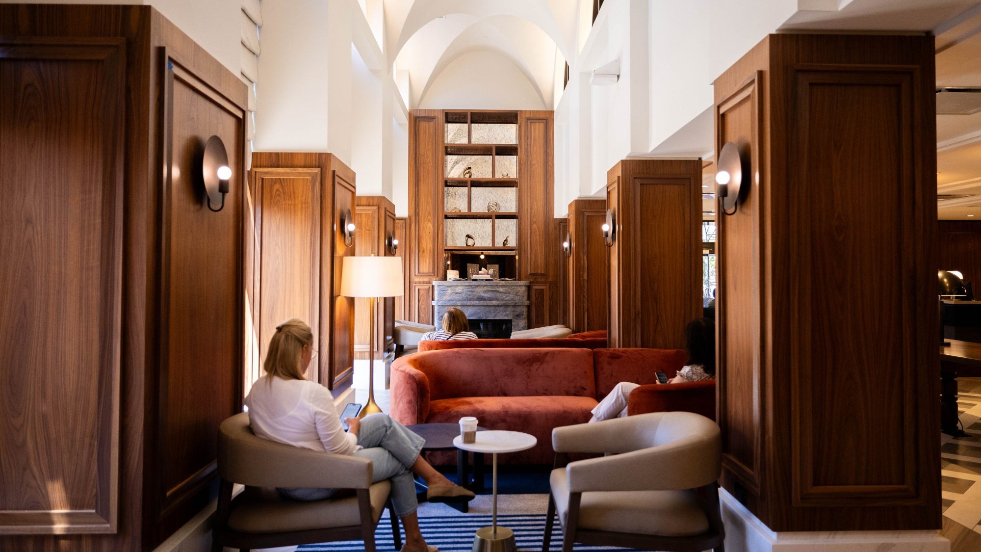 A woman sits reading in a hotel lobby