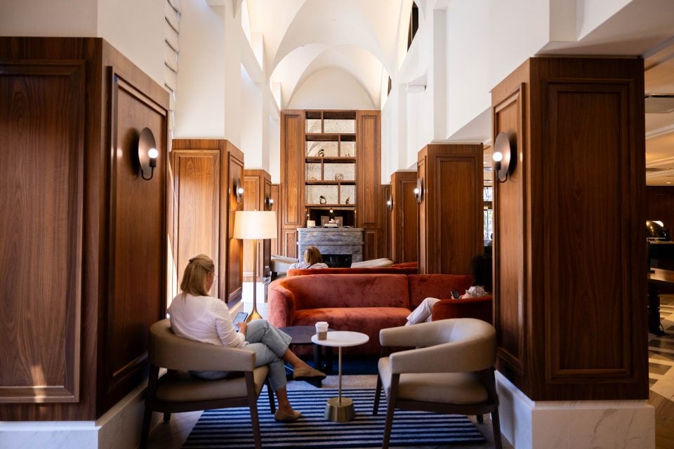 A woman sits reading in a hotel lobby