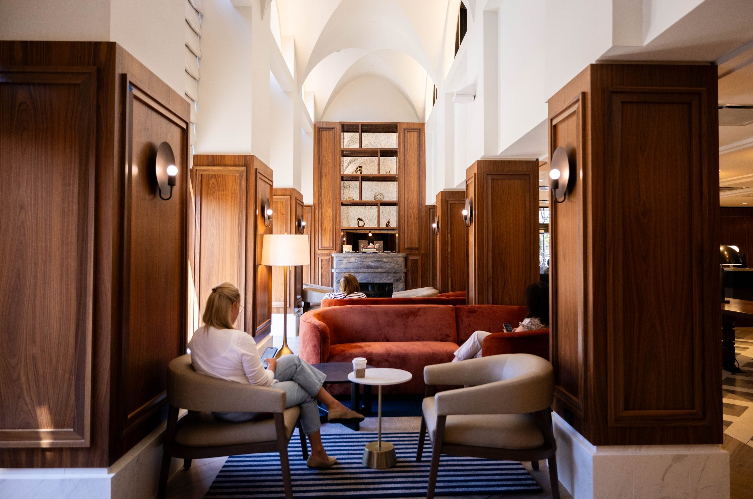 A woman sits reading in a hotel lobby