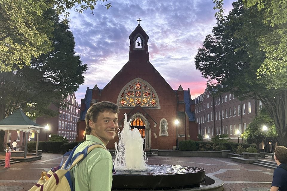 Young man with backpack in the evening by Dahlgren Chapel