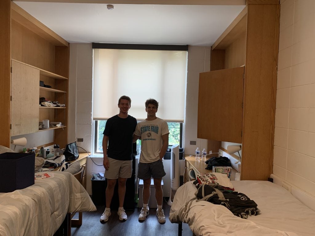 Two young men smiling in dorm room