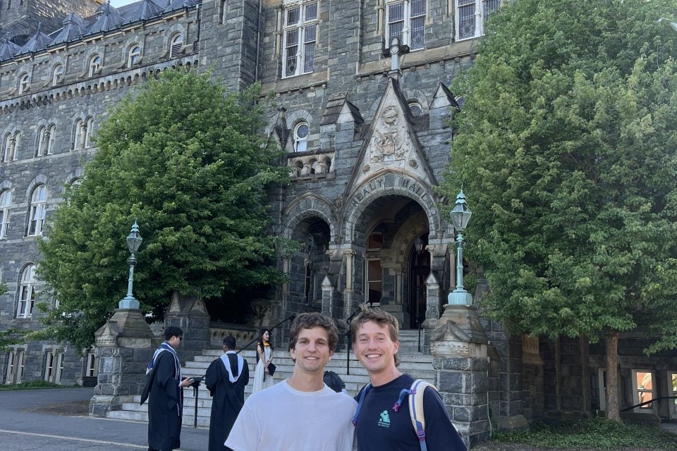 Two young men in front of Healy Hall