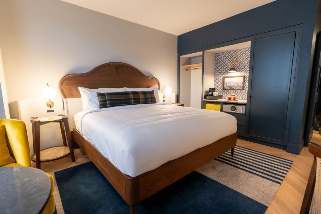 A hotel bed set against a white wall