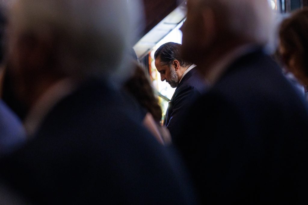 A man looks down reflecting in the background of others