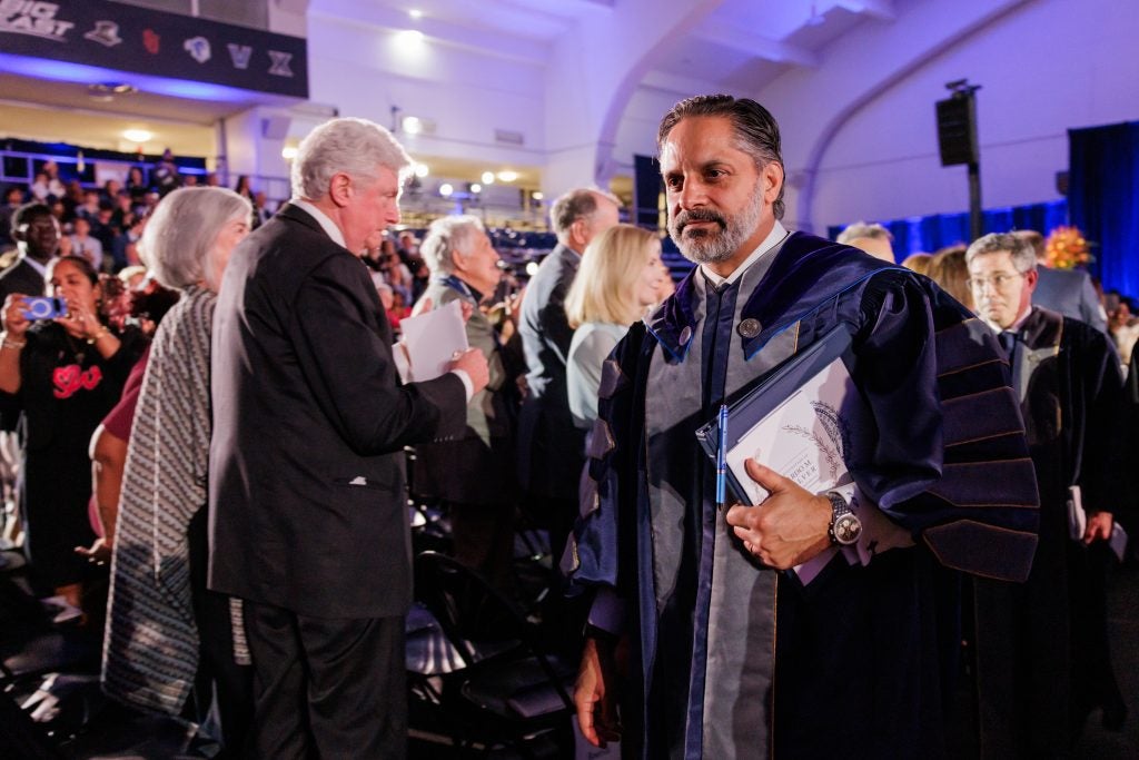 Georgetown's president walks through a cheering crowd dressed in academic robes