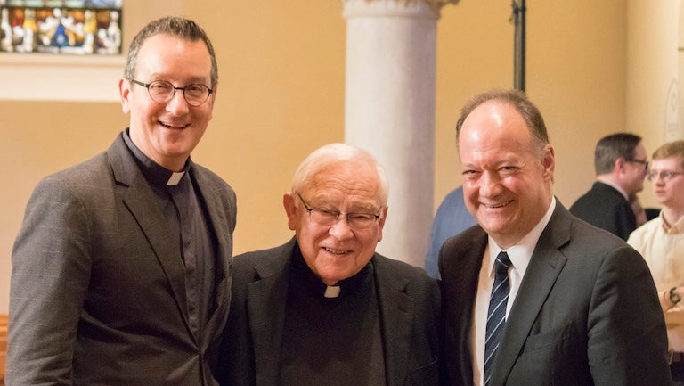 Mark Bosco, S.J. and President DeGioia stand on either side of Howard Gray, S.J.