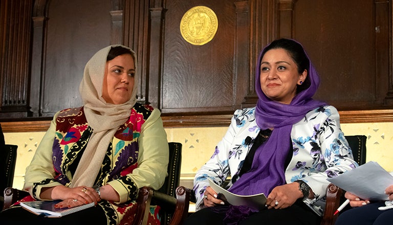 Roya Ramani and Palwasha Kakar sit in chairs wearing hijabs