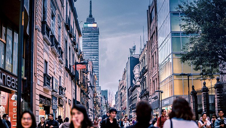 people walking between large buildings in a city