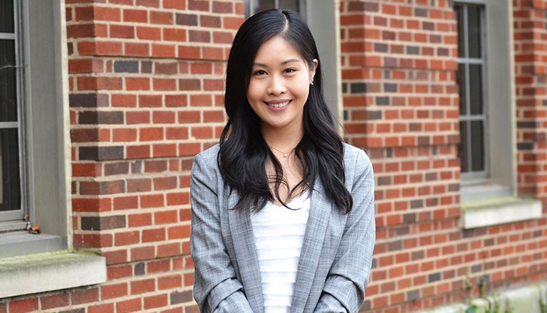 Sally Huang in front of brick building with window