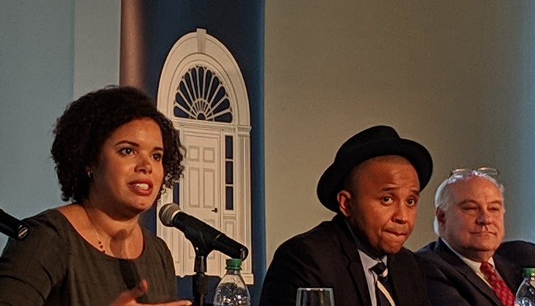 Three panelists sit behind a table.