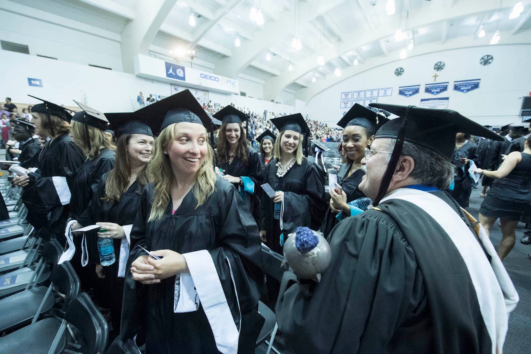 SCS graduates and administrator carrying the university mace