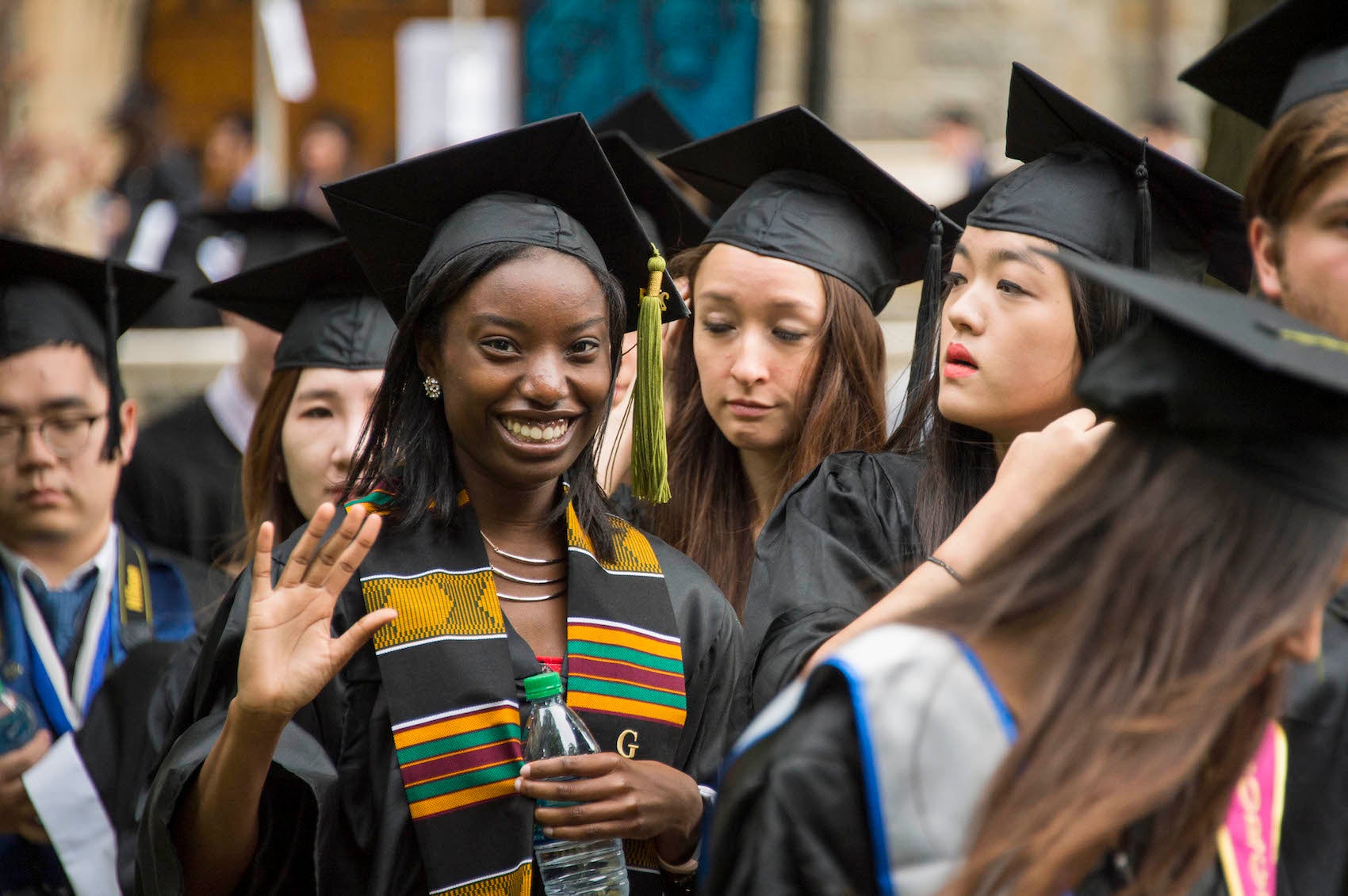 Smiling graduates in commencement attire 