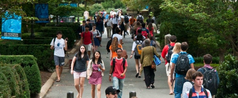 An overhead shot of students, wearing backpacks, walking around campus.