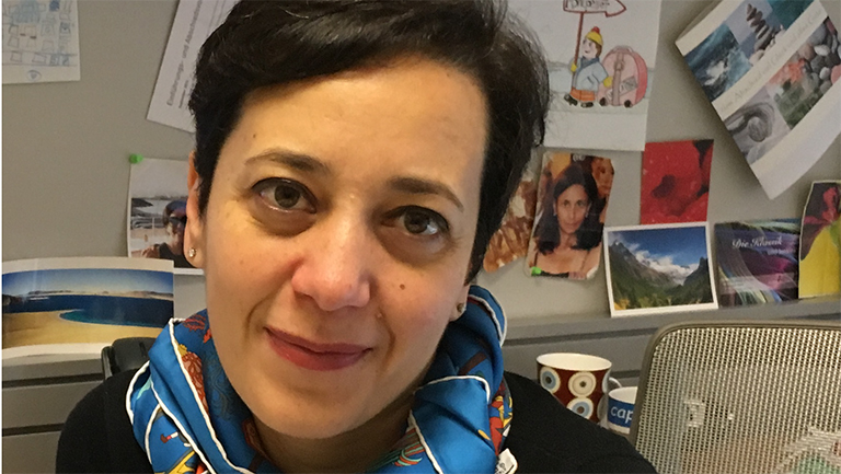 Emanuela Del Gado sitting at her desk with photos and drawings behind her