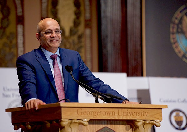 Paul Almeida speaks at a lectern in Gaston Hall