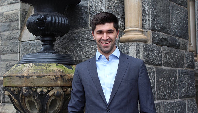 Tomás Álvarez Belón stands to the side of Healy Hall with a smile