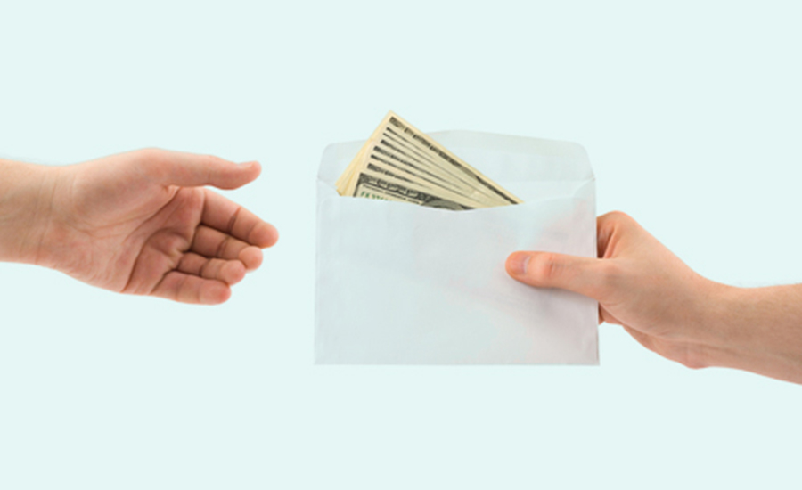Hand handing over an envelope with money in it to another hand