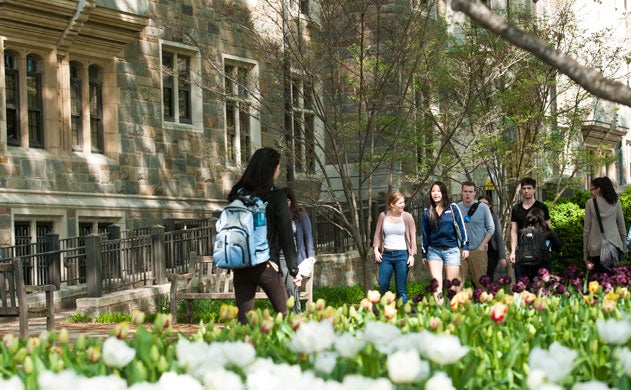 Students, wearing backpacks, walk to class.