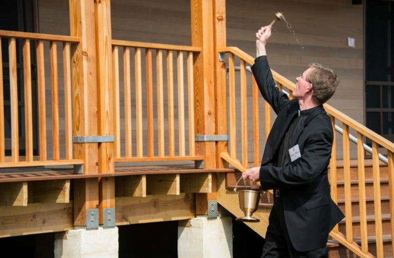 Rev. Philip Boroughs, S.J., College of the Holy Cross president, blesses the the center's cabins. 