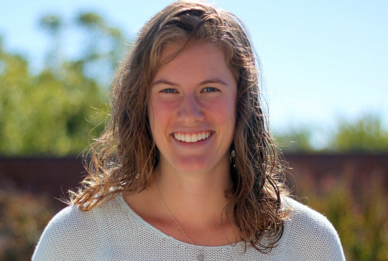 Christina Johnson smiles into the camera with a bright outdoor background.