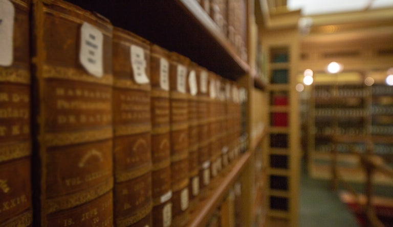 Rows of books stand on multiple shelves in Riggs Library.