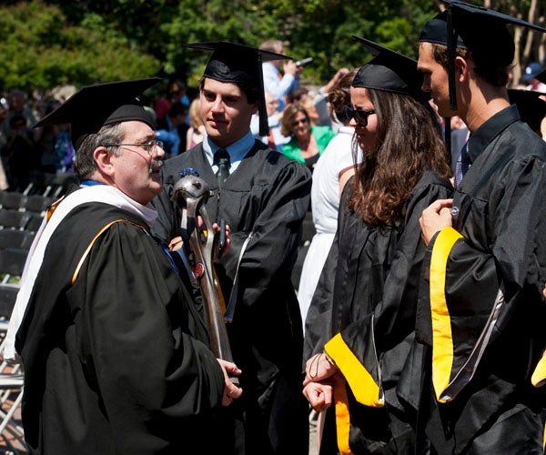 John Pierce speaks to students in line for graduation