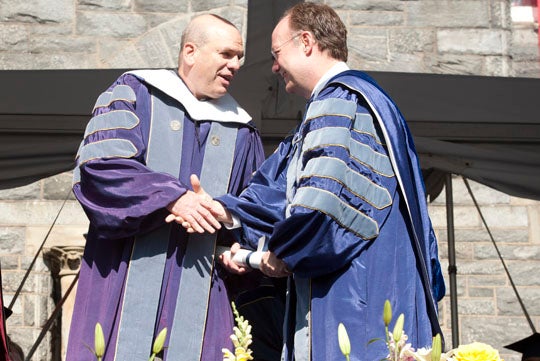 David Simon shakes hands with John J. DeGioia on stage