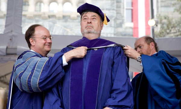 John J. DeGioia and William Treanor place hood on Arthur Gajarsa on stage on Healy Lawn