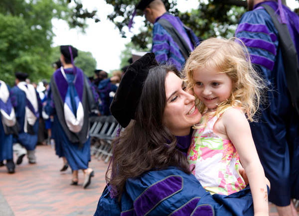 Law Graduate hugs young daughter on Healy Lawn