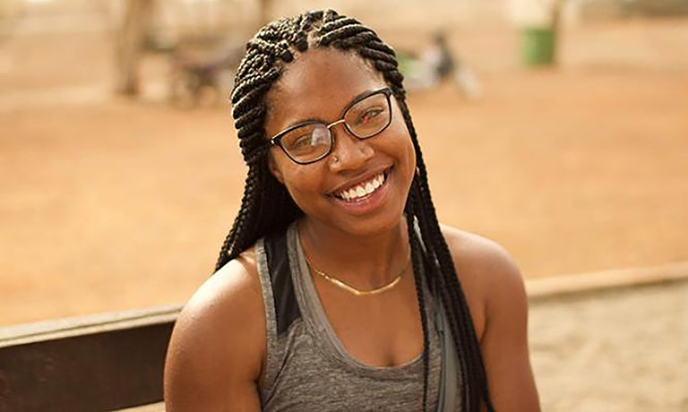 Corine Forward sits outside smiling into the camera.