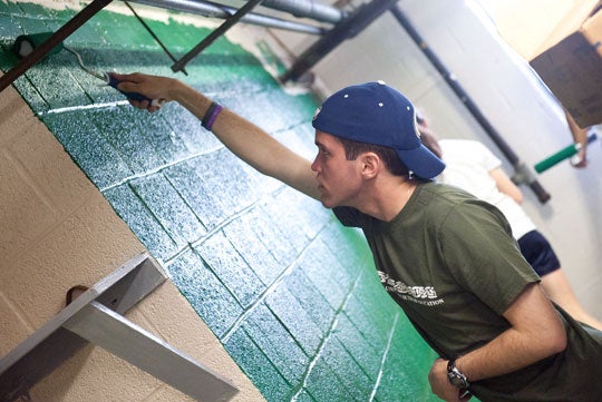 Student volunteer paints room