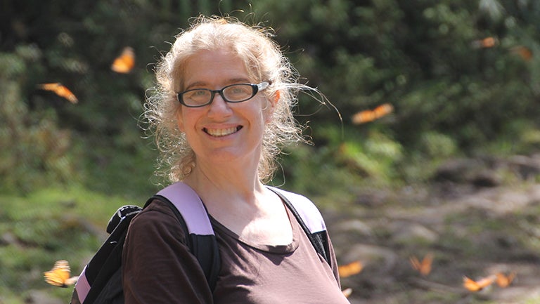 Leslie Ries with monarch butterflies hovering around her