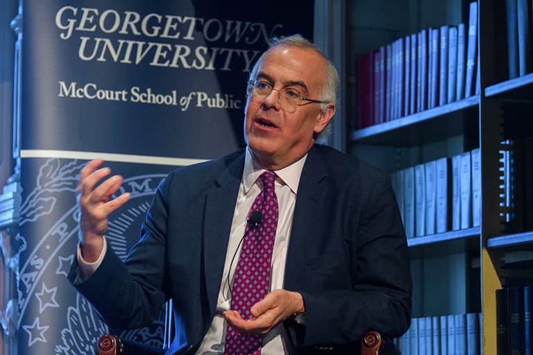 New York Times columnist David Brooks speaks to the audience while seated on stage in Riggs Library.