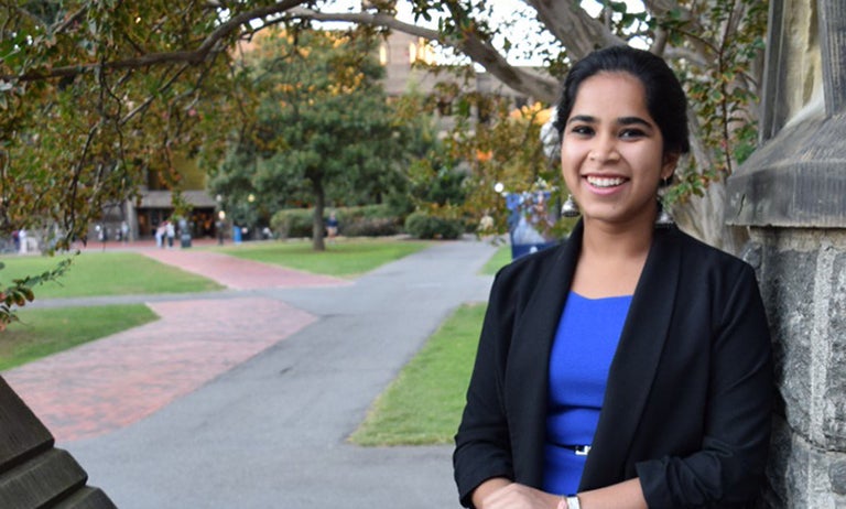 Devika Ranjan poses with part of Healy Hall in the background