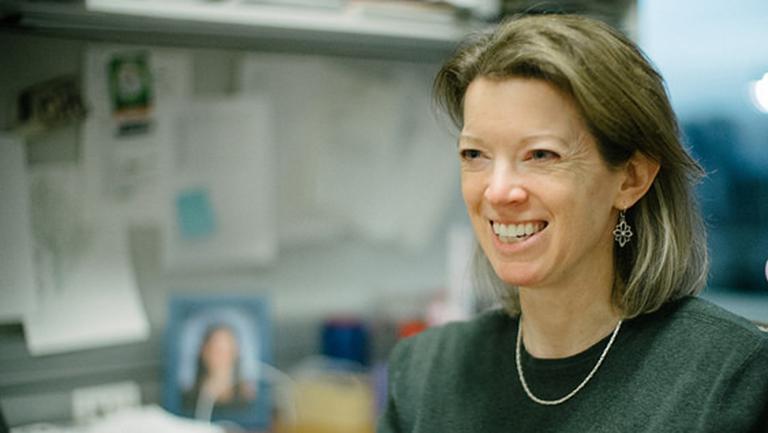 Heidi Elmendorf standing next to her desk