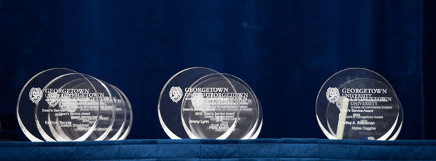 A closeup of a faculty award, pictured against a dark blue background.