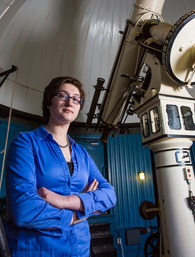 Grace Maglierin stands in the campus observatory near the telescope