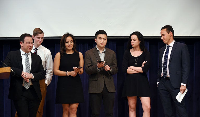 Marty Tankleff, Alex Feltes, Nada Eldaief, Steven Xie, Isobella Goonetillake and Marc Howard on stage with Nada and Steven holding cell phones