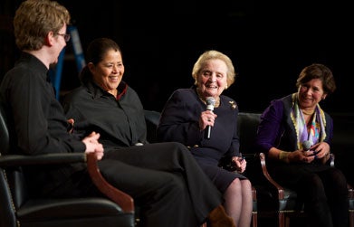 Madeleine Albright speaks on stage in Gaston Hall while Anna Deavere Smith and Joshua Roman look on