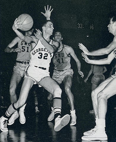 Paul Tagliabue prepares to shoot the basketball as three players from another team watch